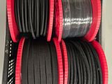plusieurs fils noirs et rouges dans un boîtier noir posé sur une surface blanche