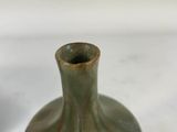 a small green vase sitting on a white surface
