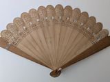 a wooden fan that is hanging on the wall
