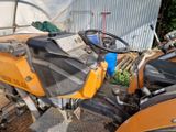 un tracteur jaune garé devant un bâtiment