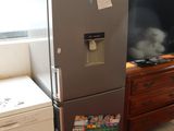 a refrigerator in the corner of a room with a tv on