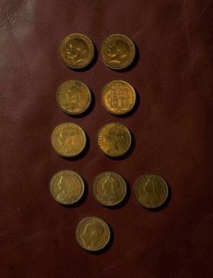 a lot of coins that are on a brown leather surface