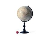 un petit globe terrestre posé sur un socle, avec une boule rouge