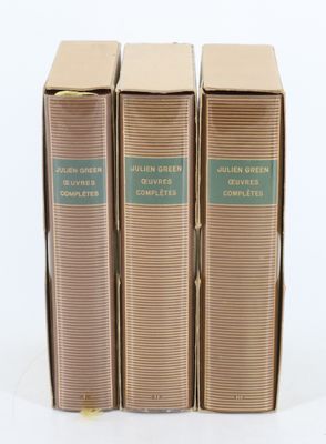 trois livres sont empilés sur une surface blanche