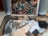 une valise ouverte remplie d'une multitude de vieilles photos et de papiers