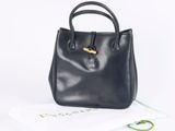 the black leather handbag is sitting on top of a book