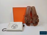 une paire de sandales marron et un sac posés sur une table