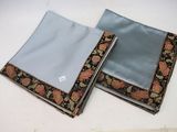 two pieces of cloth with a pattern on them sitting on top of a table