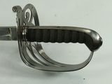 a close up of a sword on a white surface