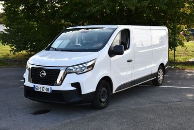 une camionnette blanche garée sur un parking, près d'un arbre