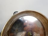 un gros plan d'un plateau en argent sur lequel se trouve une horloge