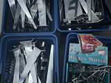 four trays of knives and a book sitting on a table
