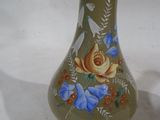 a green vase with blue flowers painted on it