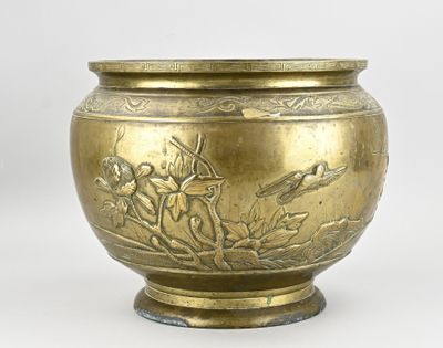 un vase en or orné d'un motif représentant un oiseau et des fleurs