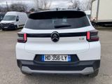 the rear of a white car parked in a parking lot