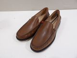 a pair of brown loafers on a white surface
