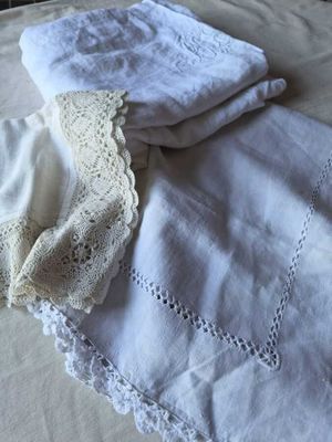 une couverture blanche sur un lit, à côté de deux serviettes blanches