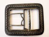 une boucle de ceinture en métal sur laquelle est fixée une boucle en métal