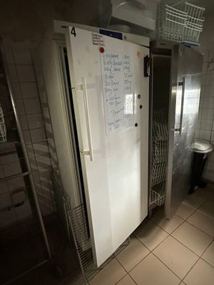 a refrigerator in a bathroom with a lot of magnets on the door