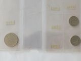 four different coins in a plastic case on a table