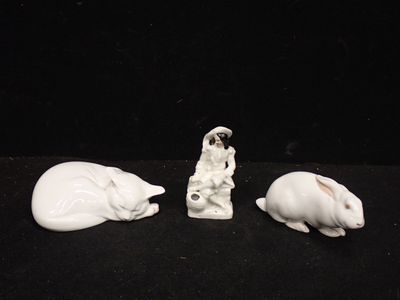 trois figurines d'animaux posées sur une surface noire