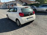a small white car that is parked in a parking lot