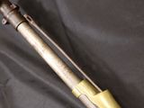a close up of a rifle on a black cloth with a wooden handle