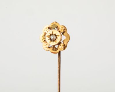 une fleur en or sur une tige, avec un diamant au centre