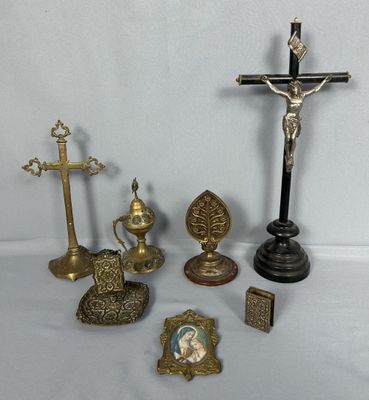 une croix, un crucifix, un cadre photo et d'autres objets religieux posés sur une table
