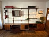 a room with a desk, shelves, and a chair in it