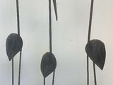three metal sculptures of birds on a white surface with a white background