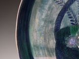 a picture of a blue and green plate with flowers on it