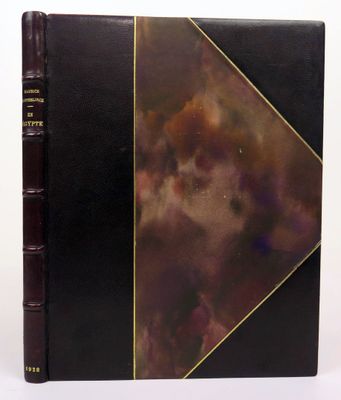 un livre noir aux bords dorés, avec une couverture marron sur fond blanc