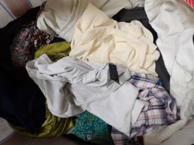un tas de vêtements dans une valise posée par terre