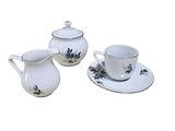three cups and a saucer on a white table