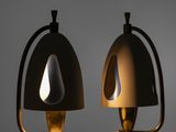 two black and gold lamps on a table in a dark room