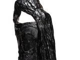 the statue of a woman is sitting on a rock with her hands on her head
