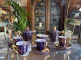 five cups and saucers sitting on a glass table