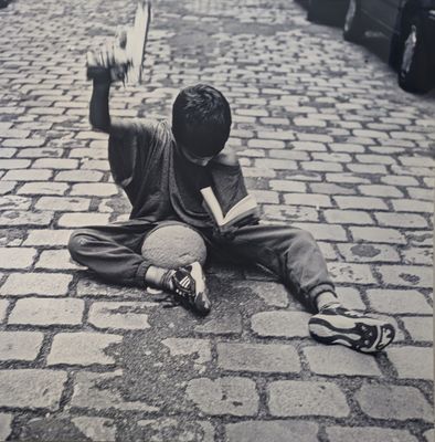 un jeune garçon assis par terre avec un skateboard