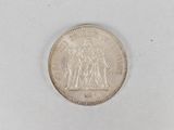 an old silver coin on a white surface with a white background