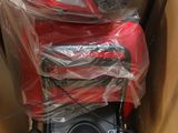 une moto rangée dans un carton, avec quelques sacs posés dessus