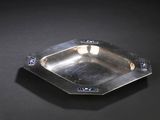 a silver plate on a black surface with blue crystals