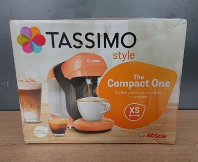 une boîte contenant une cafetière de type Tassimo posée sur une table