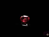 a close up of a red diamond on a black surface