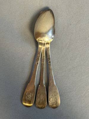 three spoons that are sitting on a table