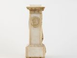 a white marble pedestal with a clock on top of it