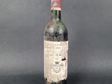 an old bottle of wine sitting on top of a table