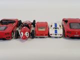 five toy cars lined up in a row on a white surface