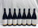 six bottles of wine are lined up on a table