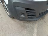 the front bumper of a white truck with a black grill